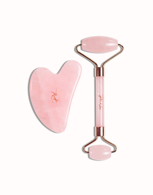 Gua sha et roller en quartz rose naturel, présentés sur un fond blanc, mettant en valeur leur qualité et leur finition élégante.